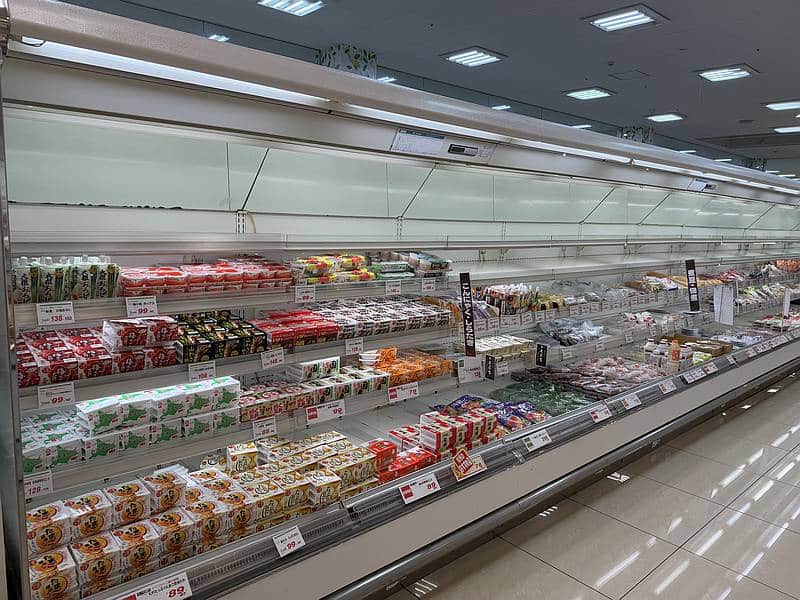 明日2025年5月12日に閉店を迎えるため、フードワン多摩境店の売り場の陳列棚には空きが目立つ状態に