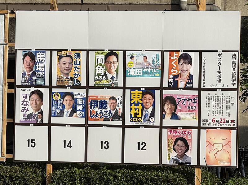 東京都議会議員選挙2025に立候補した11人の立候補者のポスターが貼られた掲示板