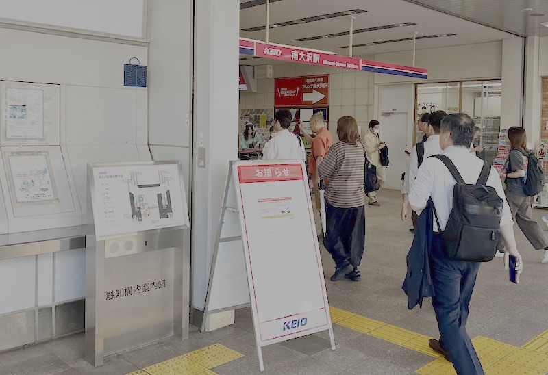 南大沢駅の改札前にお知らせの看板が立てられており、モバイルバッテリーの利用を控えるお知らせが掲示