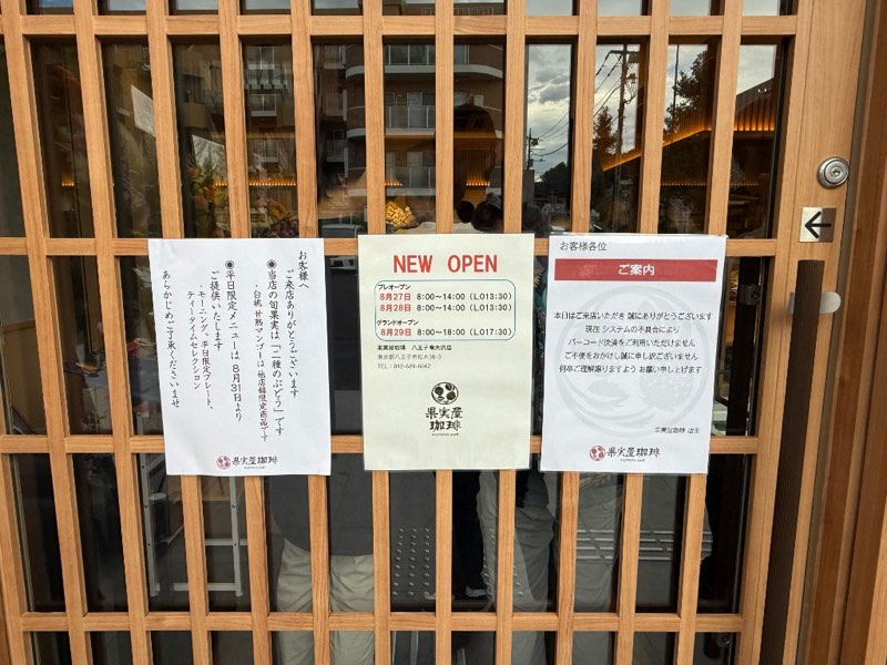 果実屋珈琲 八王子南大沢店の格子戸に掲示されたプレオープンとグランドオープンの営業時間案内