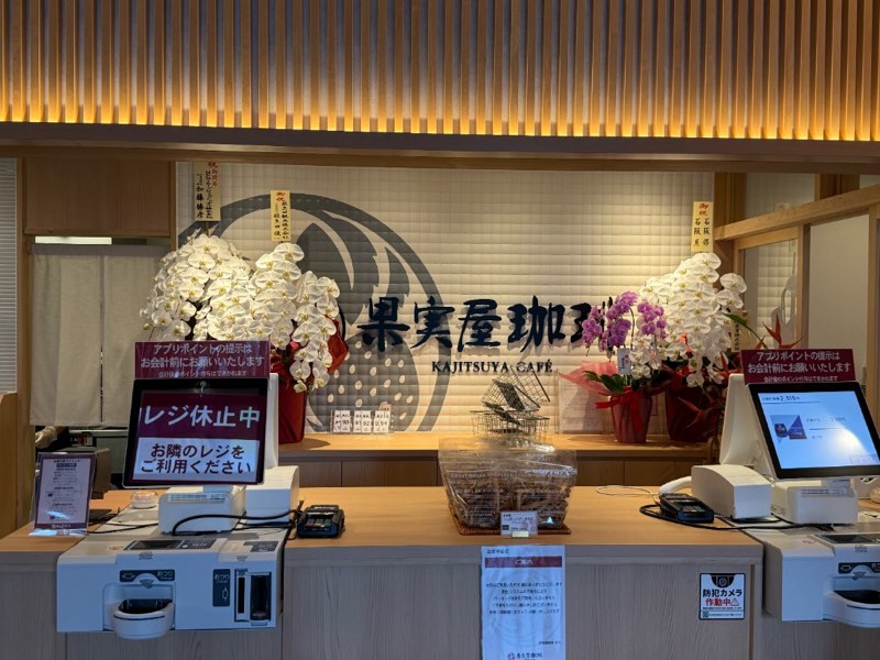 開店祝いの胡蝶蘭が並ぶ果実屋珈琲 八王子南大沢店のレジカウンター