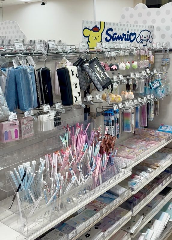 ポムポムプリンとシナモロールの看板の下に並ぶペンケースとボールペン