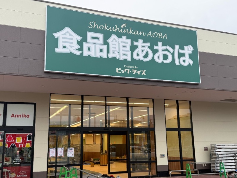 ぐりーんうぉーく多摩に設置された緑色の食品館あおば看板とガラス張りの入口
