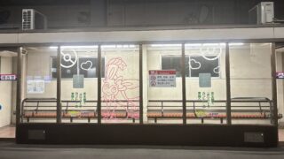 京王線南大沢駅の橋本方面ホーム待合室。ガラス中央にニンフィアの線画があり、『ポケパーク カントー』ブイブイヴォヤージュ・スタンプラリーの装飾としてハートとモンスターボールも描かれている