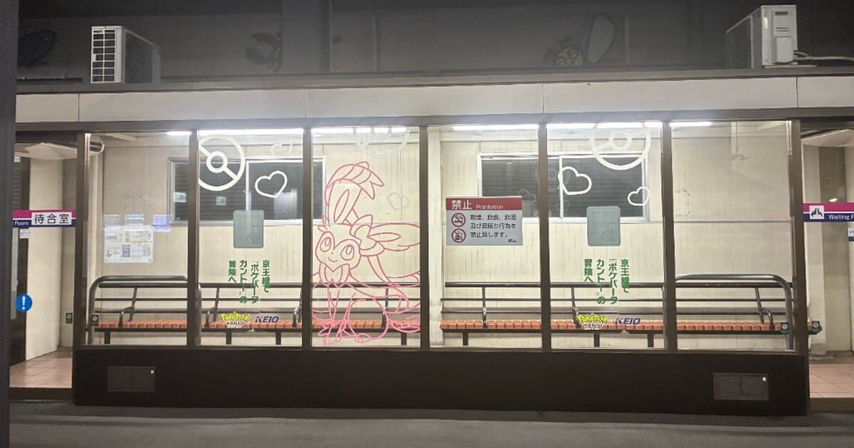 京王線南大沢駅の橋本方面ホーム待合室。ガラス中央にニンフィアの線画があり、『ポケパーク カントー』ブイブイヴォヤージュ・スタンプラリーの装飾としてハートとモンスターボールも描かれている