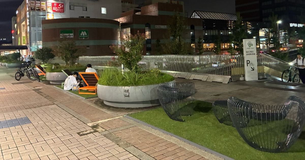 イトーヨーカドー南大沢店前の人工芝に置かれた、3つの円孔がある黄緑色のトンネル状オブジェ