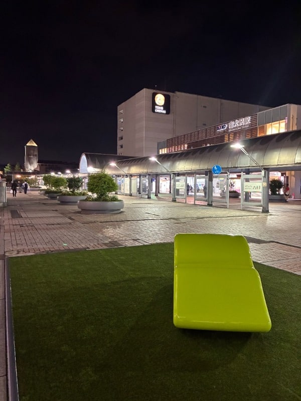 TOHOシネマズ南大沢前のデッキ。緑色の人工芝の上に黄緑色の寝椅子が1脚置かれている