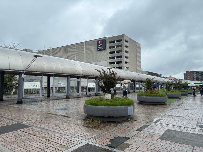 雨で濡れた南大沢駅前の歩行空間。TOHOシネマズ南大沢側で傘を差して通行する人