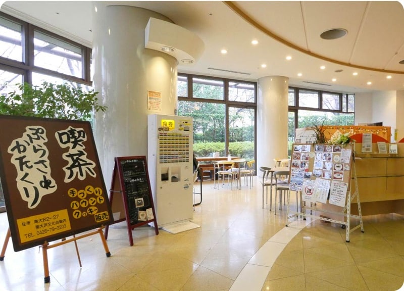南大沢文化会館内の喫茶ぷらさ・de・かたくり。手づくりパウンドクッキー販売の案内看板があるロビー