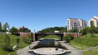 長池公園の長池見附橋。煉瓦のアーチ橋が水路をまたぎ、手前に円形のステージがある