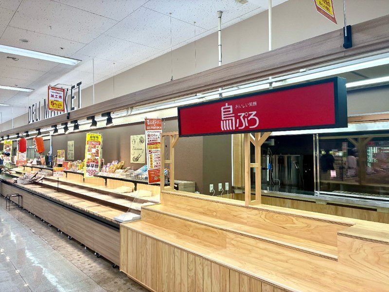 惣菜売り場に並ぶ鳥ぷろのカウンター。奥に厨房、隣に空の棚
