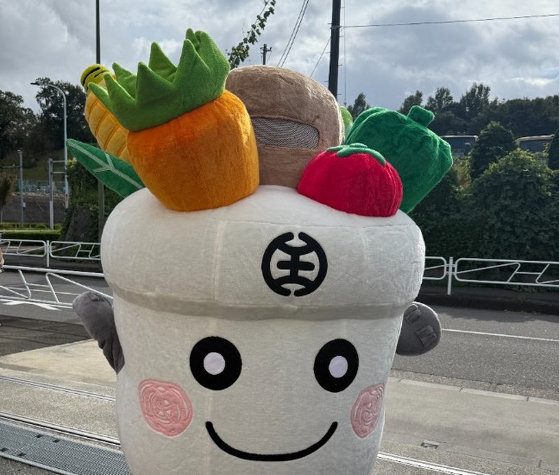 頭ににんじん、とうもろこし、トマト、パンを載せたはっちくん